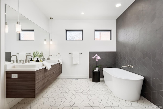 bathroom featuring tile patterned floors, vanity, a tub to relax in, and tile walls