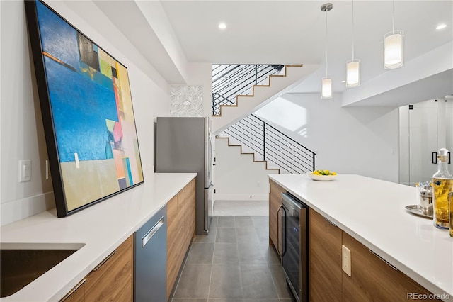 kitchen with appliances with stainless steel finishes, wine cooler, hanging light fixtures, and sink