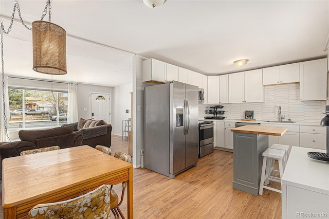 2514 E Bijou St, Colorado Springs, CO 80909 - kitchen featuring stainless steel appliances, butcher block counters, a sink, light wood-style floors, and open floor plan