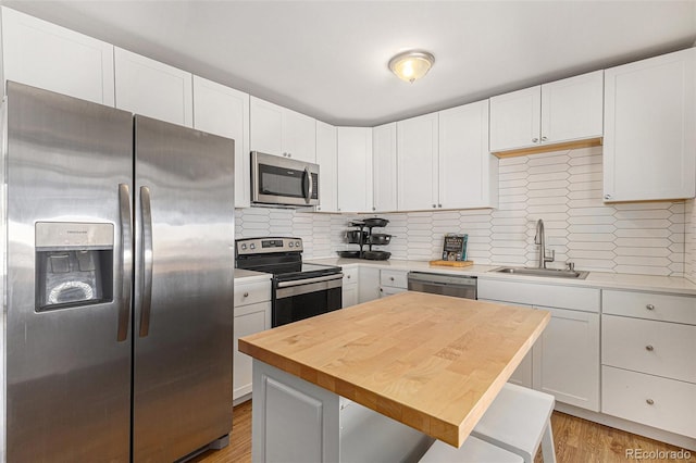 2514 E Bijou St, Colorado Springs, CO 80909 - kitchen with stainless steel appliances, a sink, backsplash, white cabinets, and wood counters