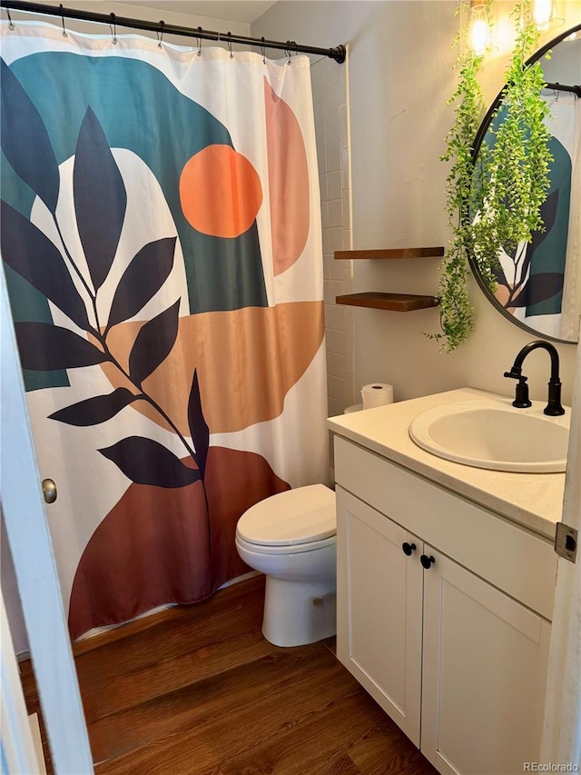 2514 E Bijou St, Colorado Springs, CO 80909 - bathroom featuring wood finished floors, toilet, vanity, and curtained shower