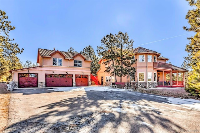 31 Black Fawn Ln, Westcliffe, CO 81252 - mediterranean / spanish-style home with concrete driveway, stucco siding, stone siding, a tiled roof, and a balcony