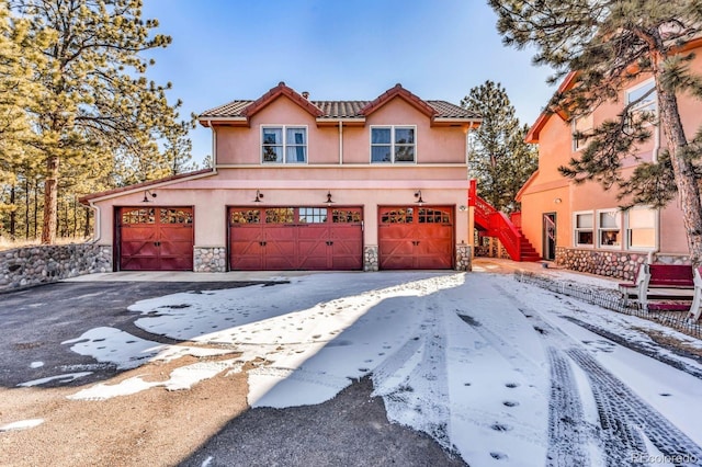 31 Black Fawn Ln, Westcliffe, CO 81252 - view of front of house with a tile roof, stone siding, stucco siding, an attached garage, and aphalt driveway