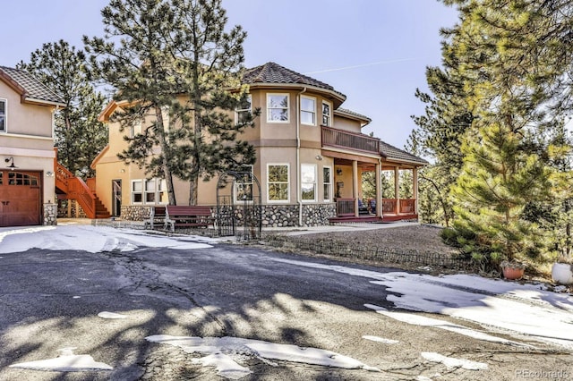 31 Black Fawn Ln, Westcliffe, CO 81252 - view of front facade with stone siding, a tiled roof, a balcony, and stucco siding