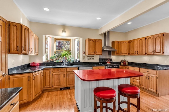 31 Black Fawn Ln, Westcliffe, CO 81252 - kitchen featuring light wood-style flooring, stainless steel range with gas stovetop, wall chimney exhaust hood, a kitchen island, and a sink