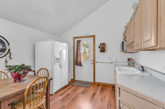31 Black Fawn Ln, Westcliffe, CO 81252 - kitchen with light countertops, light wood-style flooring, white fridge with ice dispenser, vaulted ceiling, and light brown cabinetry