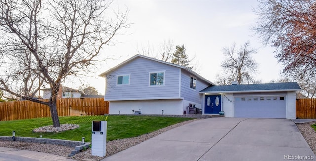 tri-level home featuring fence, concrete driveway, a garage, stucco siding, and a front yard