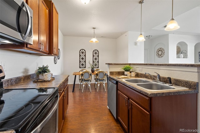 kitchen featuring decorative light fixtures, stainless steel appliances, dark hardwood / wood-style floors, and sink