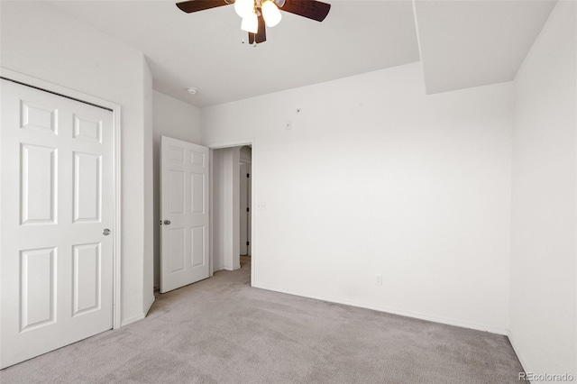 unfurnished bedroom with ceiling fan, a closet, and light colored carpet