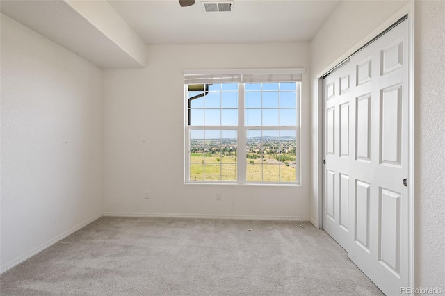 unfurnished bedroom with a closet and light colored carpet