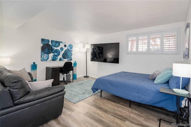 bedroom featuring baseboards and wood finished floors