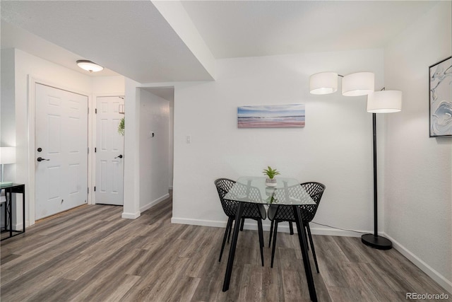 dining space with wood finished floors and baseboards