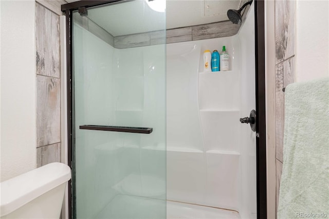 full bath featuring a shower stall and toilet