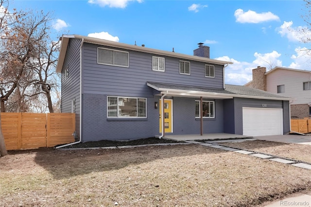 traditional home with a garage, brick siding, fence, driveway, and a chimney