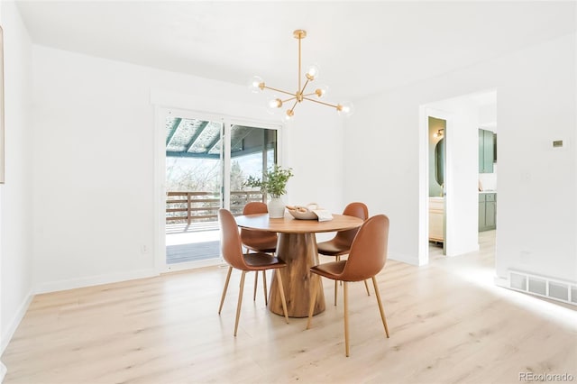 dining area with visible vents, baseboards, light wood-style floors, and a chandelier