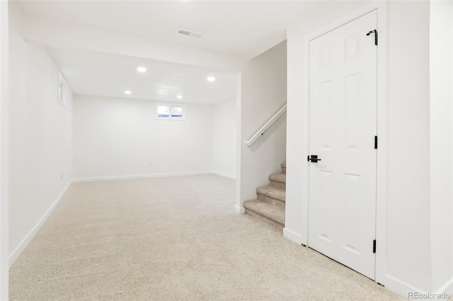 basement featuring visible vents, baseboards, stairway, light colored carpet, and recessed lighting