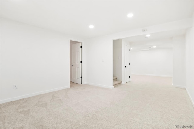 unfurnished room with recessed lighting, light colored carpet, stairway, and baseboards