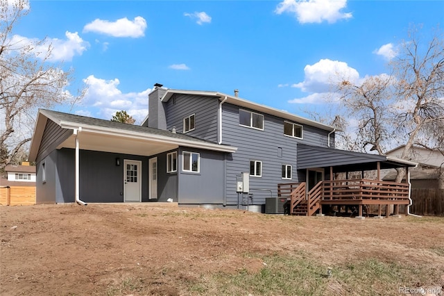 back of house featuring central AC unit, a deck, and a chimney