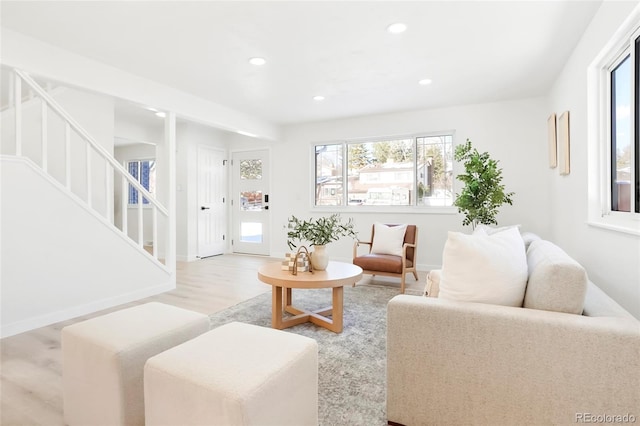 living area featuring recessed lighting, stairway, a healthy amount of sunlight, and wood finished floors