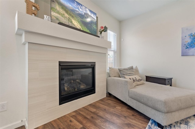 living room with dark wood-style floors and a tiled fireplace