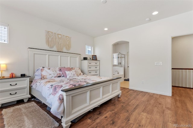 bedroom featuring connected bathroom and wood-type flooring