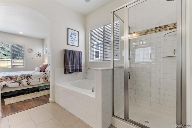 bathroom featuring tile patterned floors, a shower stall, a bath, and ensuite bathroom