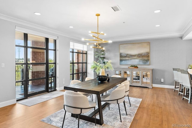 1590 Little Raven St Unit 408, Denver, CO 80202 - dining area with baseboards, light wood finished floors, an inviting chandelier, visible vents, and crown molding