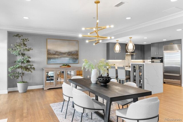 1590 Little Raven St Unit 408, Denver, CO 80202 - dining area featuring crown molding, light wood-style flooring, visible vents, and recessed lighting