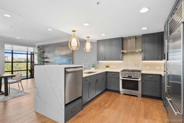 1590 Little Raven St Unit 408, Denver, CO 80202 - kitchen with a sink, a peninsula, wall chimney exhaust hood, high quality appliances, and gray cabinets