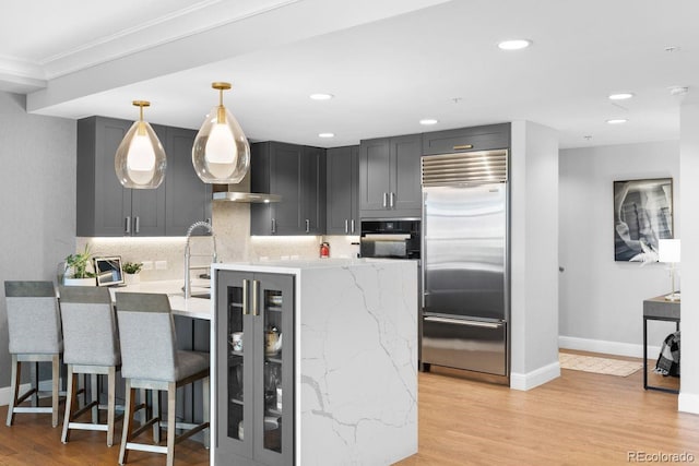 1590 Little Raven St Unit 408, Denver, CO 80202 - kitchen with black oven, built in refrigerator, baseboards, decorative backsplash, and light stone counters