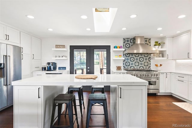 2976 Hiwan Dr, Evergreen, CO 80439 - kitchen featuring open shelves, high quality appliances, wall chimney range hood, a kitchen island, and light countertops