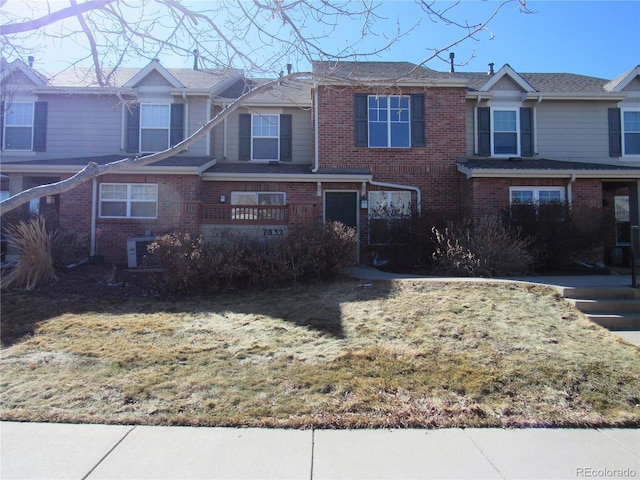 view of front of house with a front lawn and brick siding