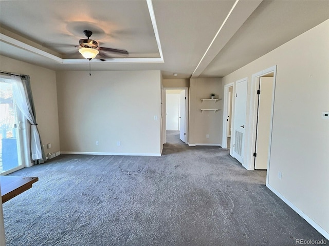 spare room featuring carpet flooring, ceiling fan, and a tray ceiling