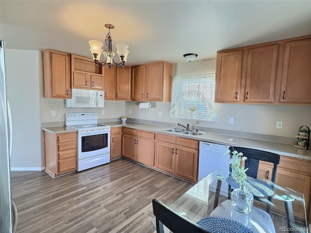 kitchen with white appliances, a chandelier, pendant lighting, light wood-type flooring, and sink