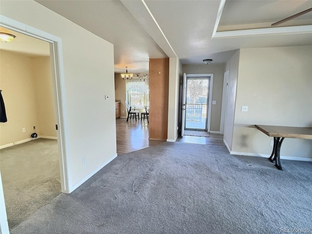 carpeted foyer entrance with a notable chandelier