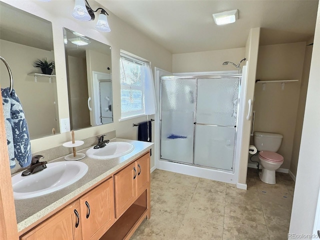 bathroom featuring vanity, a shower with shower door, and toilet