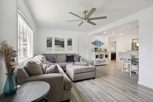 living room featuring light hardwood / wood-style flooring and ceiling fan