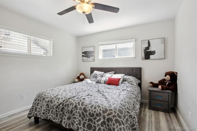 bedroom featuring wood-type flooring, multiple windows, and ceiling fan