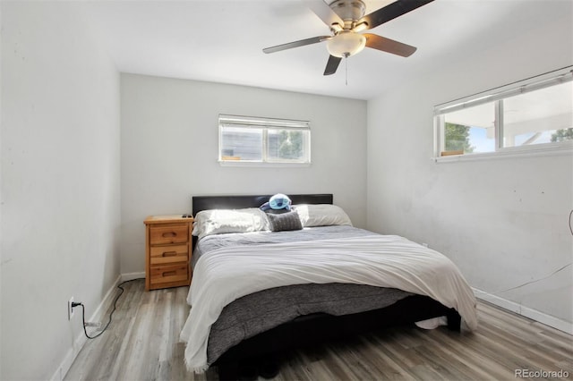 bedroom with light wood-type flooring, multiple windows, and ceiling fan