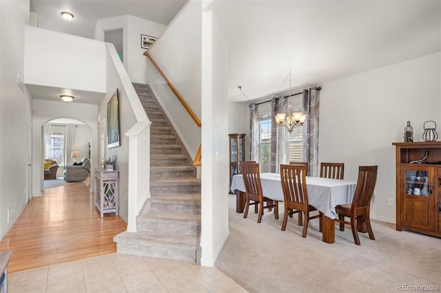 6471 S Ider St, Aurora, CO 80016 - tiled dining area featuring a chandelier, arched walkways, and stairway