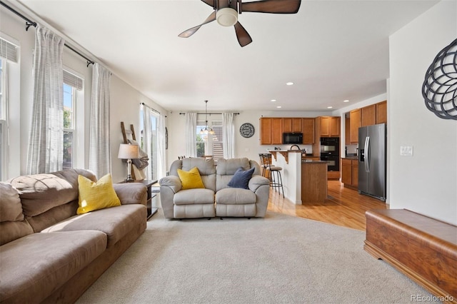 6471 S Ider St, Aurora, CO 80016 - living area featuring light carpet, a ceiling fan, recessed lighting, and light wood-style flooring