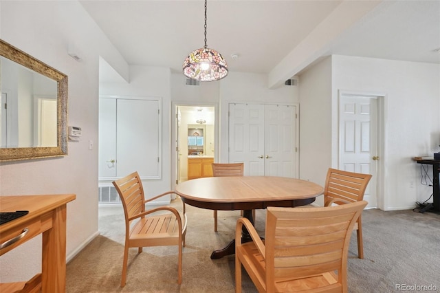dining space with light carpet and baseboards