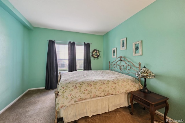 bedroom with dark colored carpet and baseboards