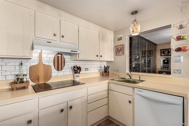 kitchen with decorative light fixtures, backsplash, black electric stovetop, sink, and white dishwasher