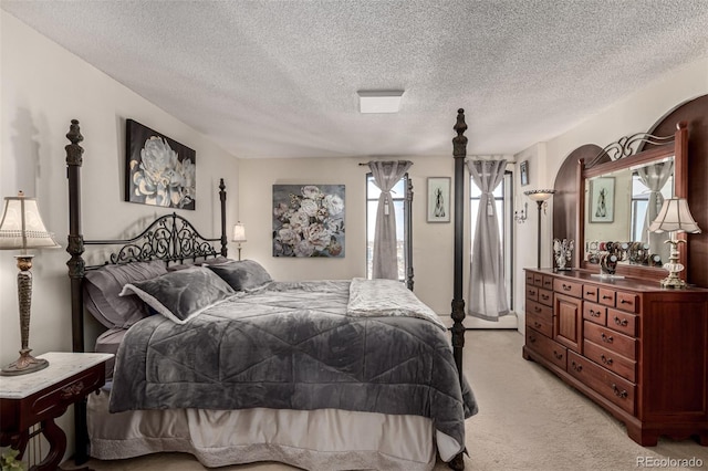 bedroom featuring a textured ceiling and light carpet