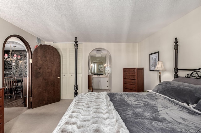 bedroom with light carpet and a textured ceiling