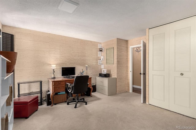 carpeted home office with a textured ceiling