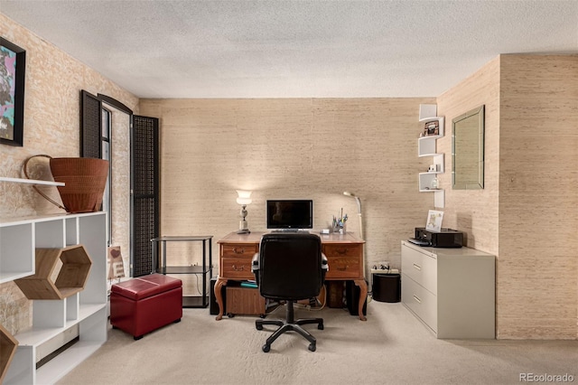 carpeted office featuring a textured ceiling