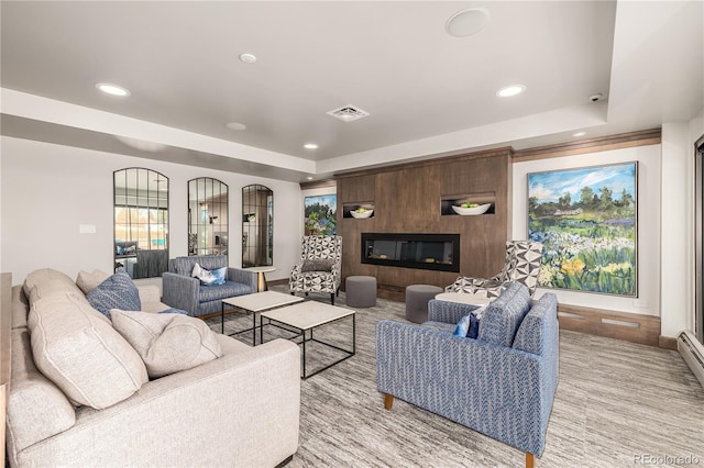 living room with a fireplace and a raised ceiling