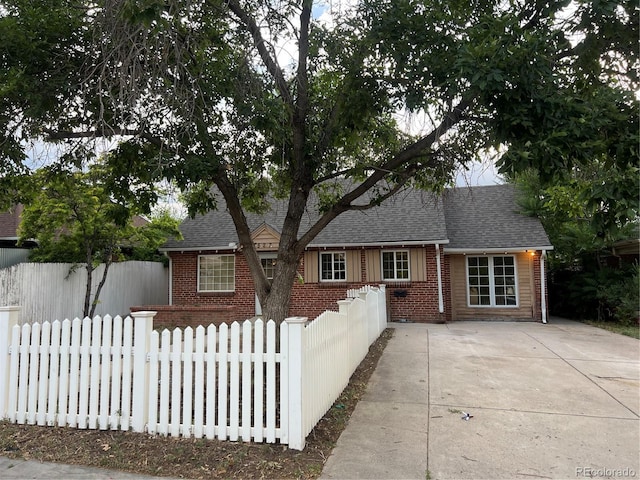 527 S Bryant St, Denver, CO 80219 - view of front of property featuring brick siding, a fenced front yard, and roof with shingles